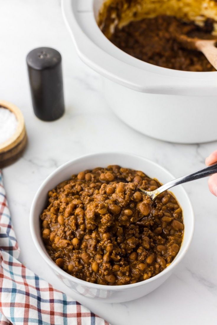 white bowl of baked beans with ground beef