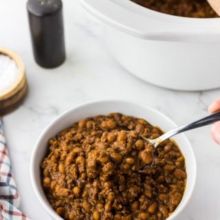 white bowl of baked beans with ground beef