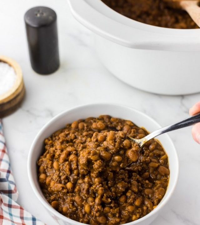 white bowl of baked beans with ground beef