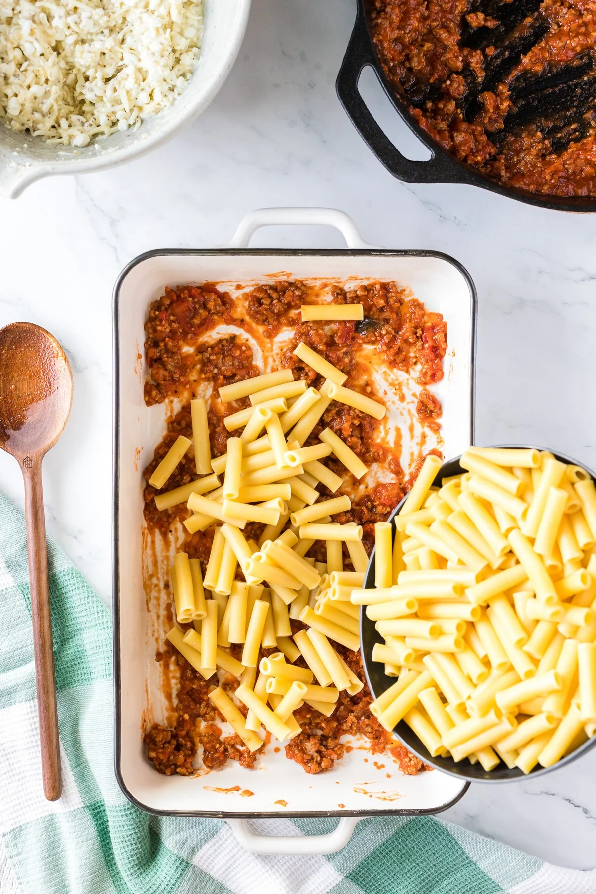 layering baked ziti with pasta and sauce