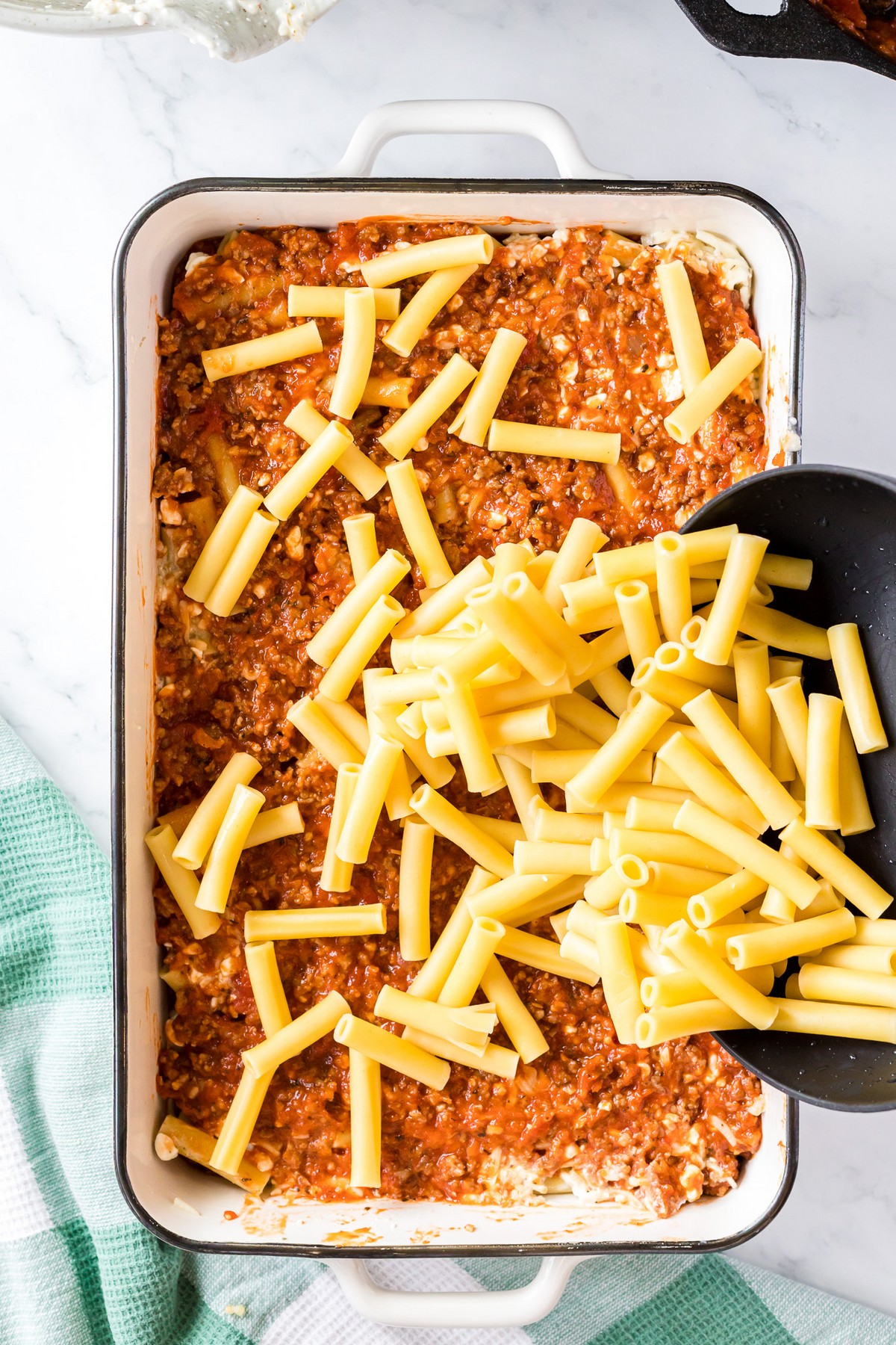 adding pasta to baked ziti layer