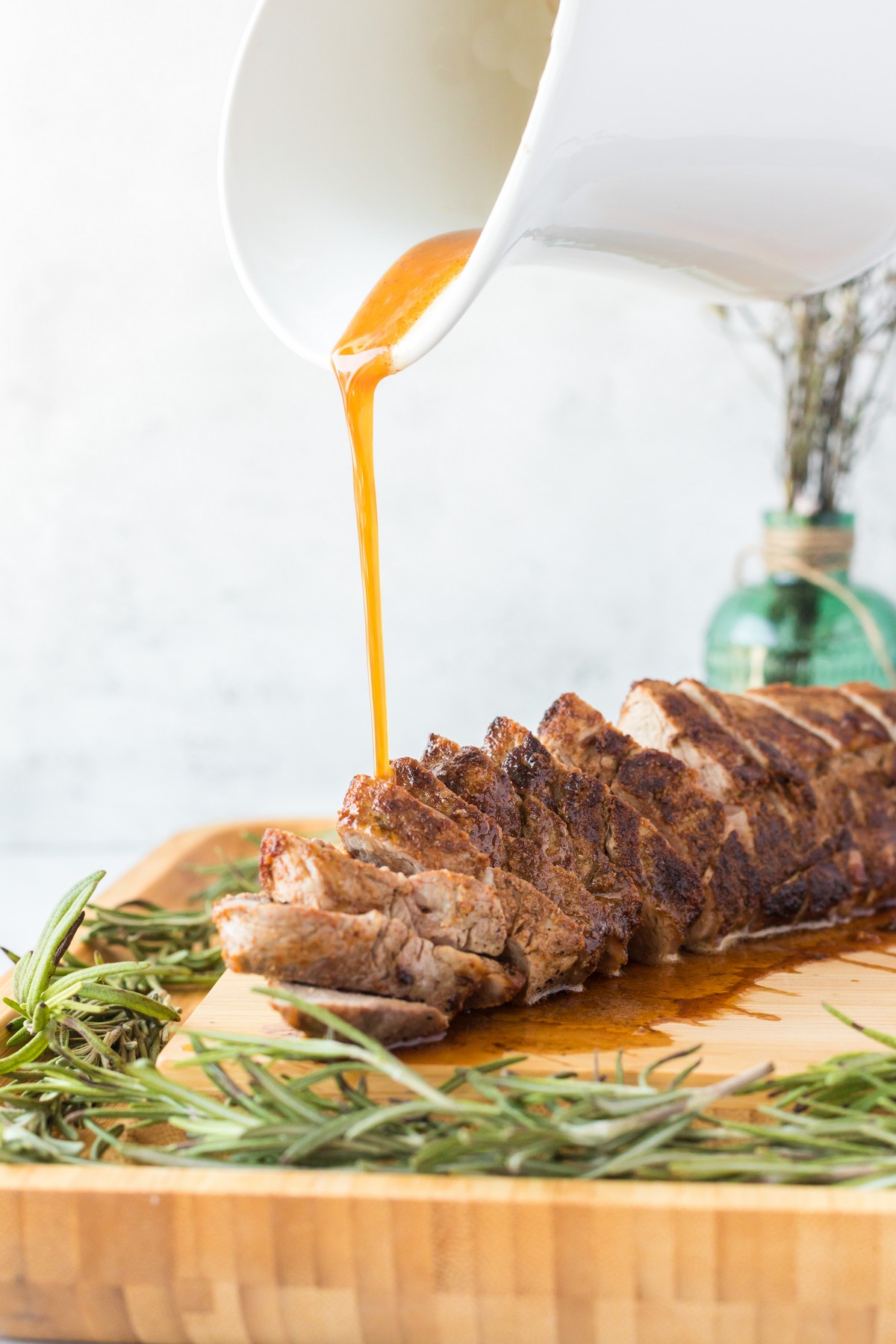 pouring pan sauce over pork tenderloin