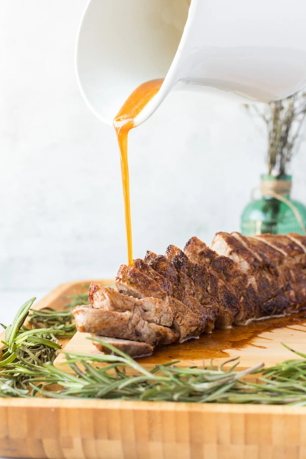 pouring pan sauce over pork tenderloin