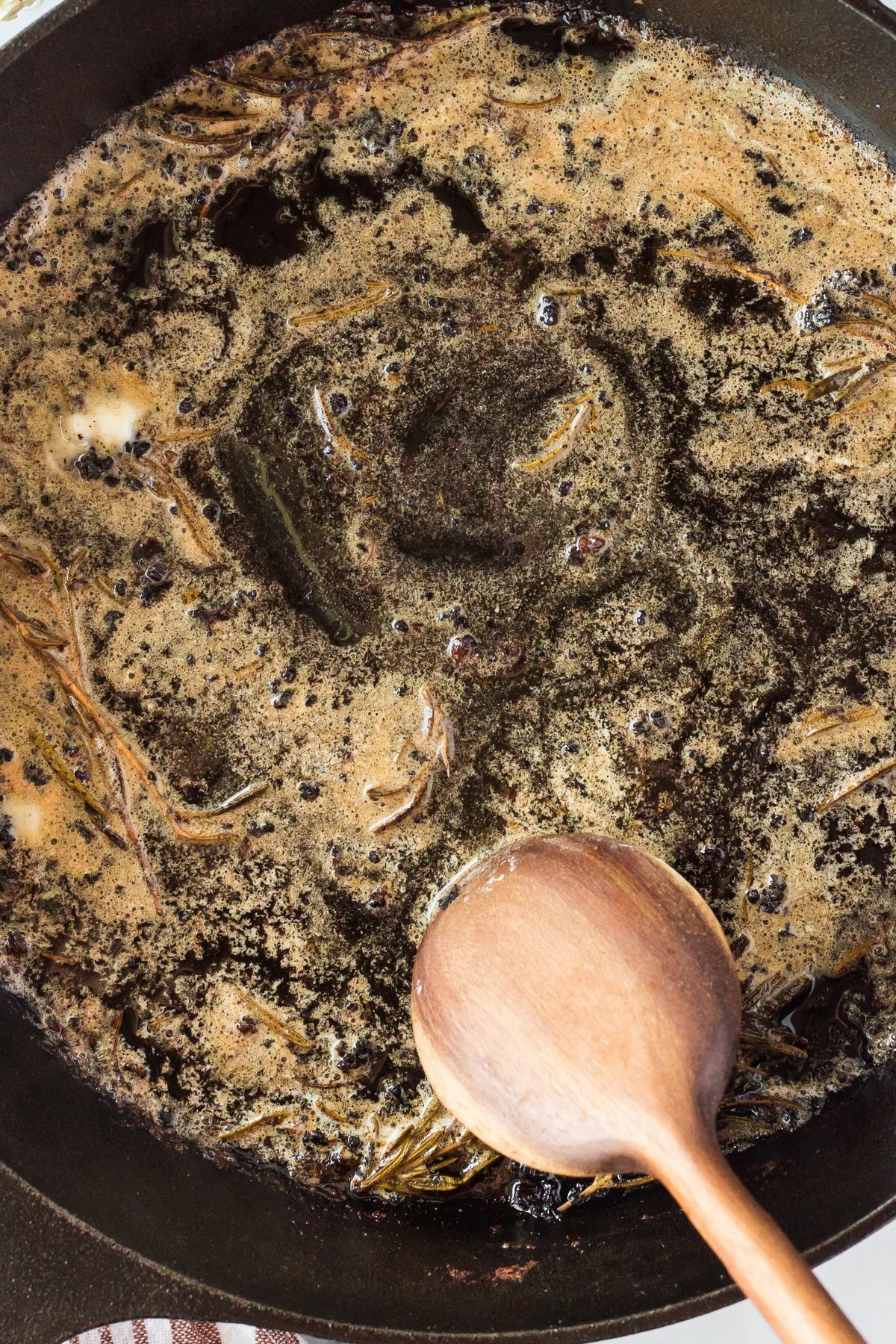 scraping up fond in skillet for pan sauce