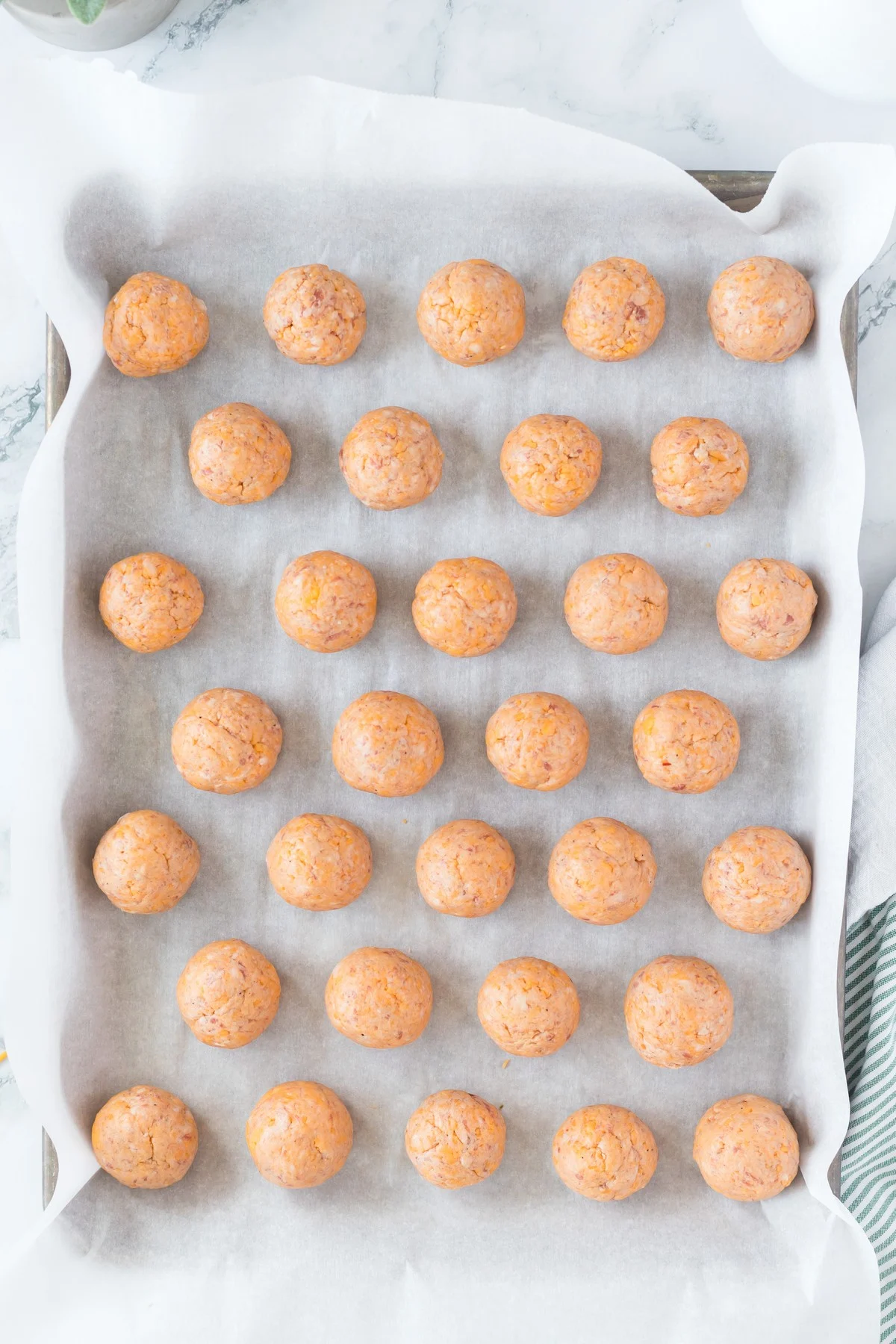 uncooked sausage balls on sheet pan