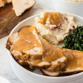 tender and juicy turkey breast with gravy and side dishes