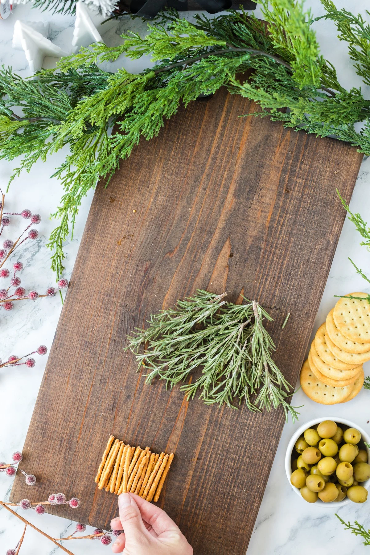 making a Christmas Charcuterie Board tree trunk with pretzels