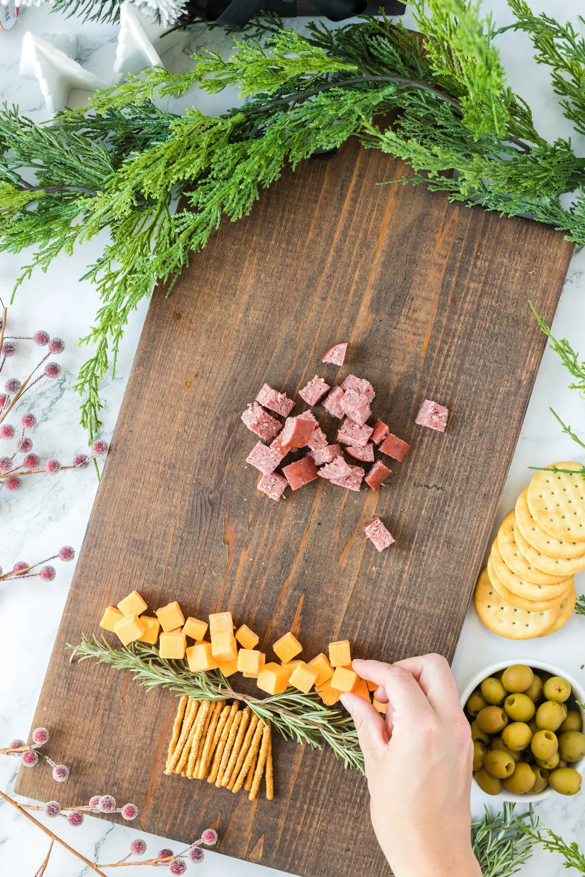 layering cheese cubes on a Christmas Charcuterie Board
