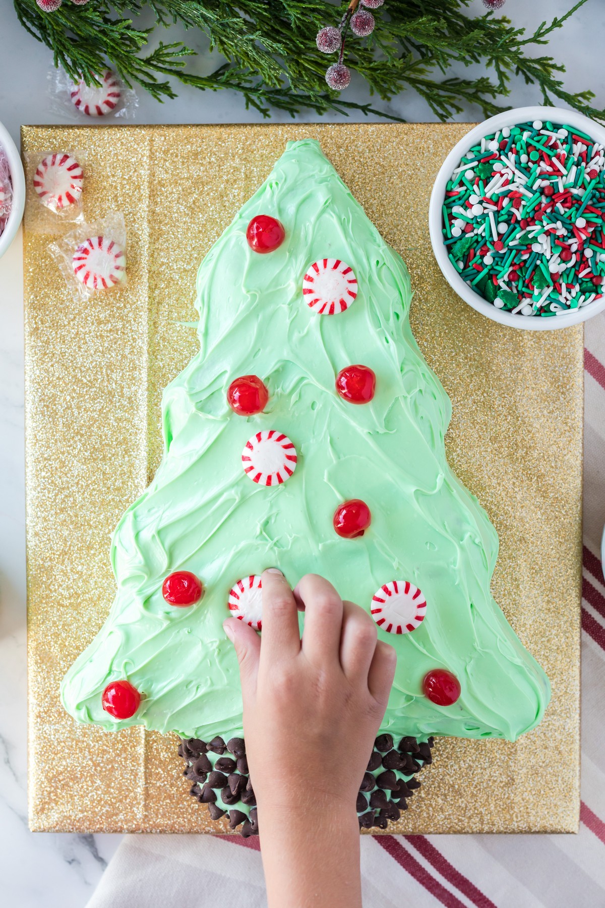 adding peppermints to a christmas tree cake