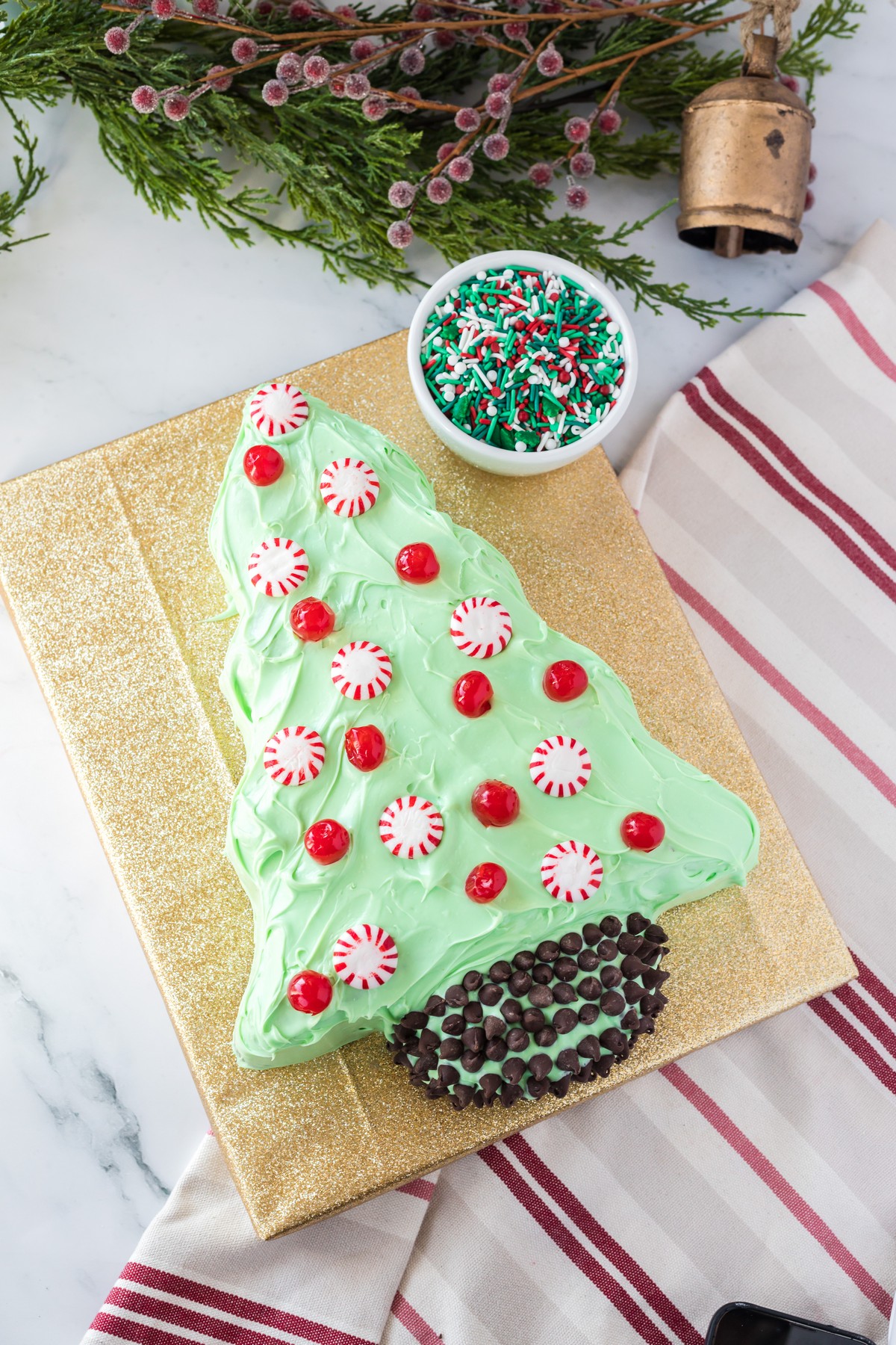 decorating a christmas tree cake with peppermints and maraschino cherries