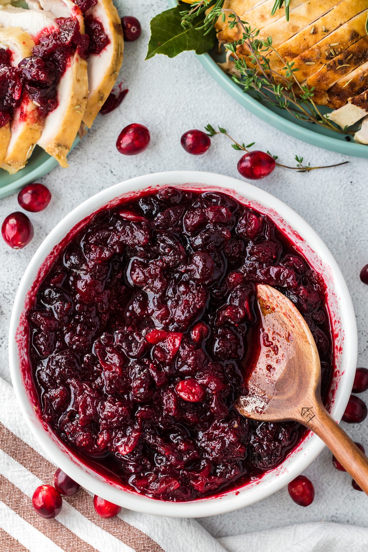 cranberry sauce in white bowl with turkey in background