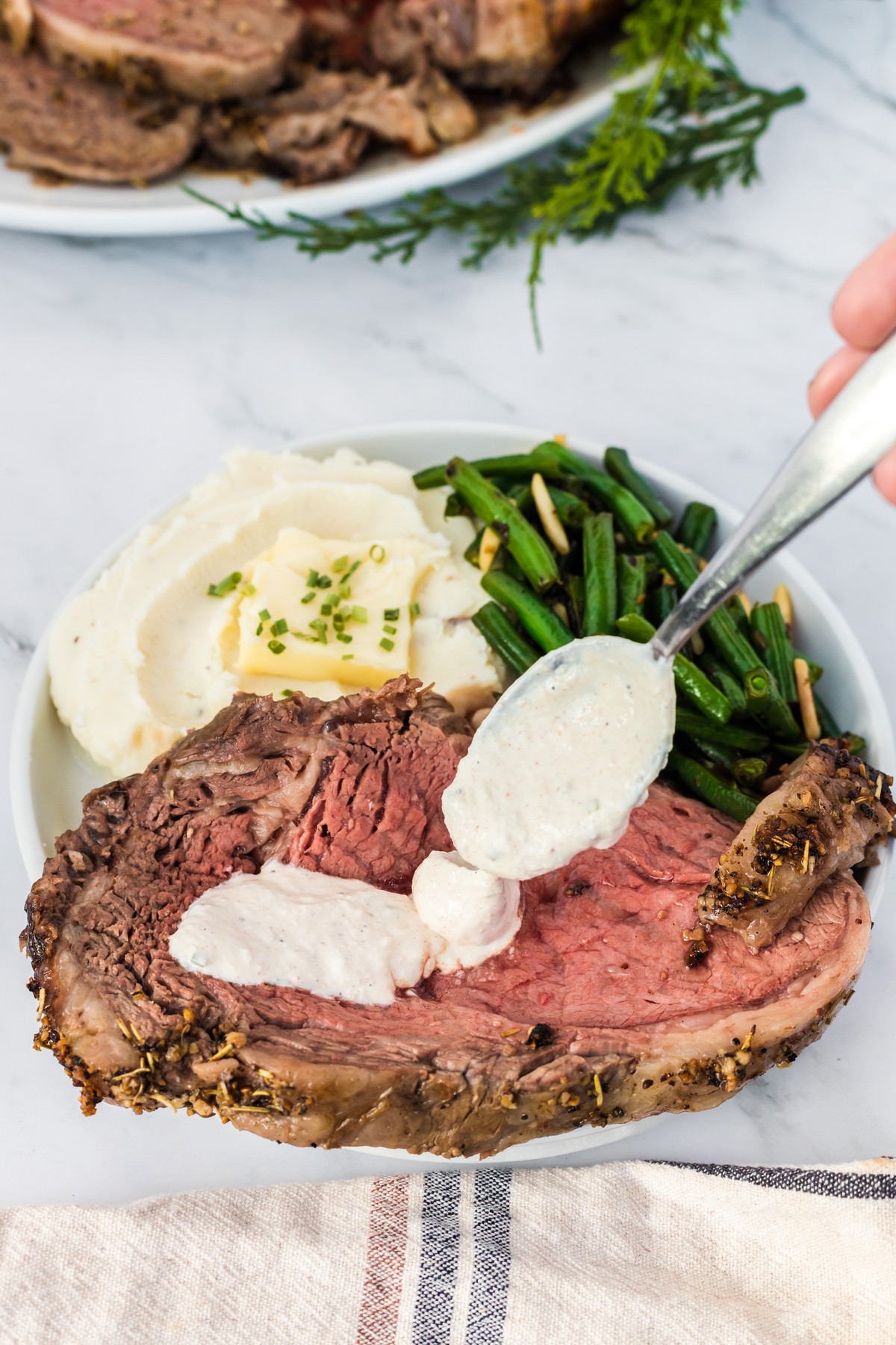 adding horseradish cream sauce to prime rib