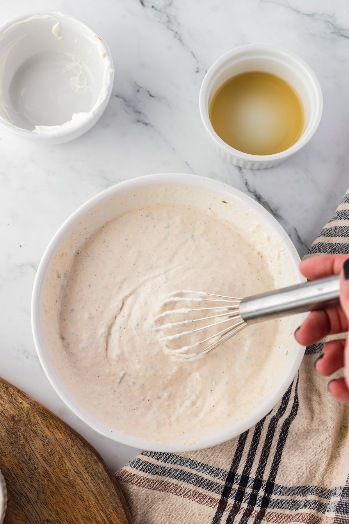 whisking ingredients to make horseradish cream sauce