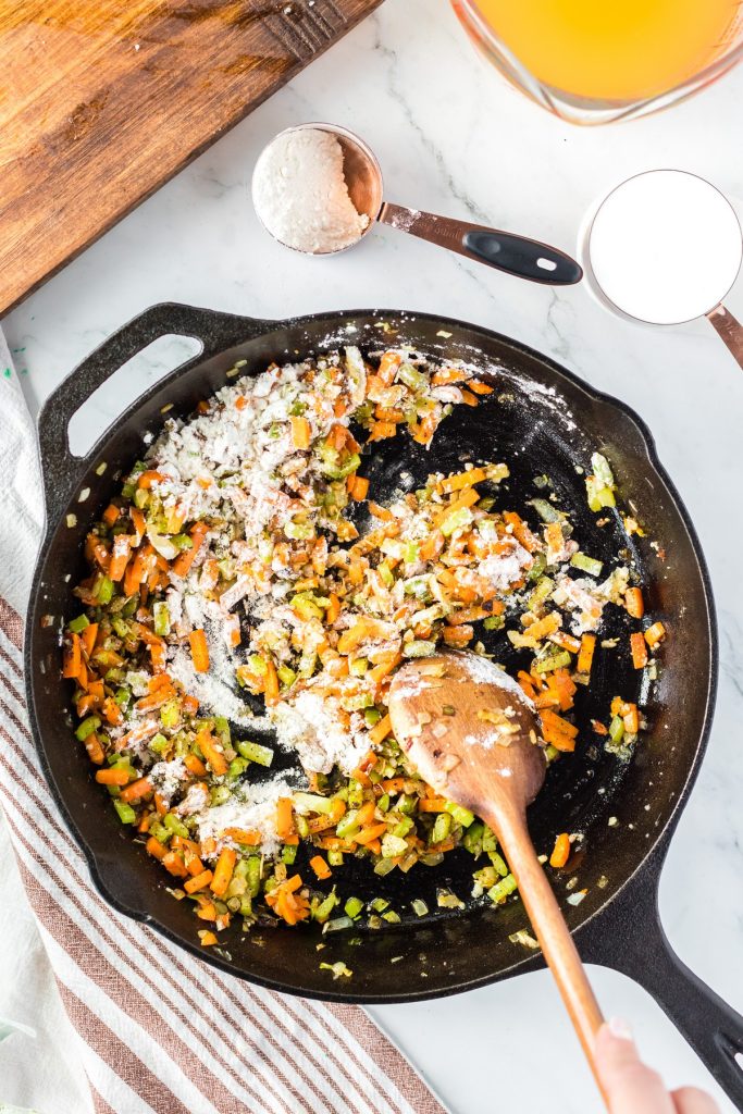 whisking flour into vegetables