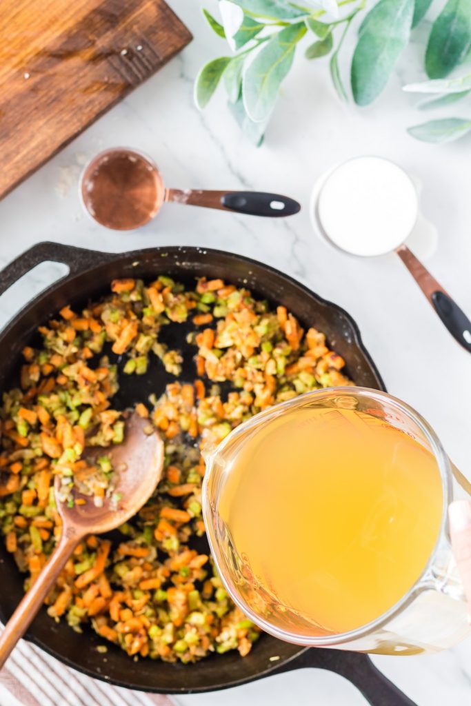 adding chicken broth to vegetable mixture