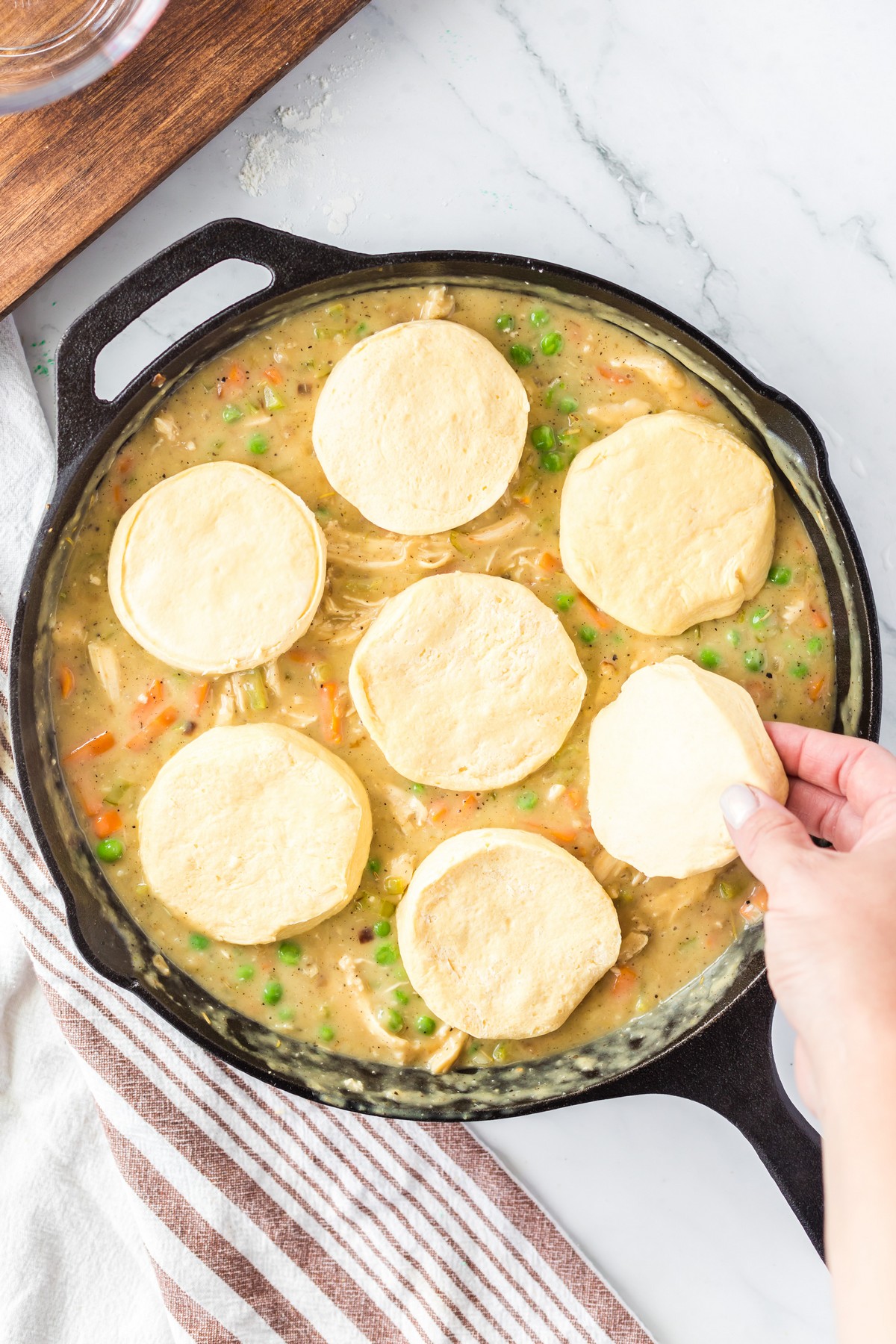 adding uncooked biscuits to turkey pot pie mixture