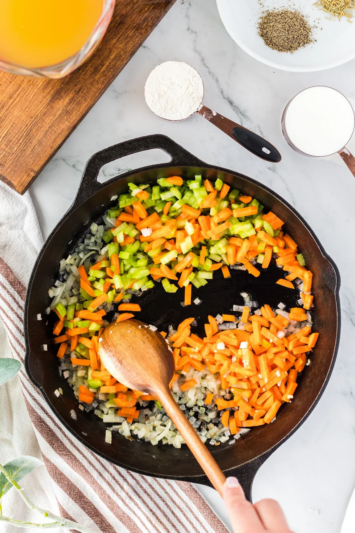sauteing a mirepoix in a black cast iron skillet