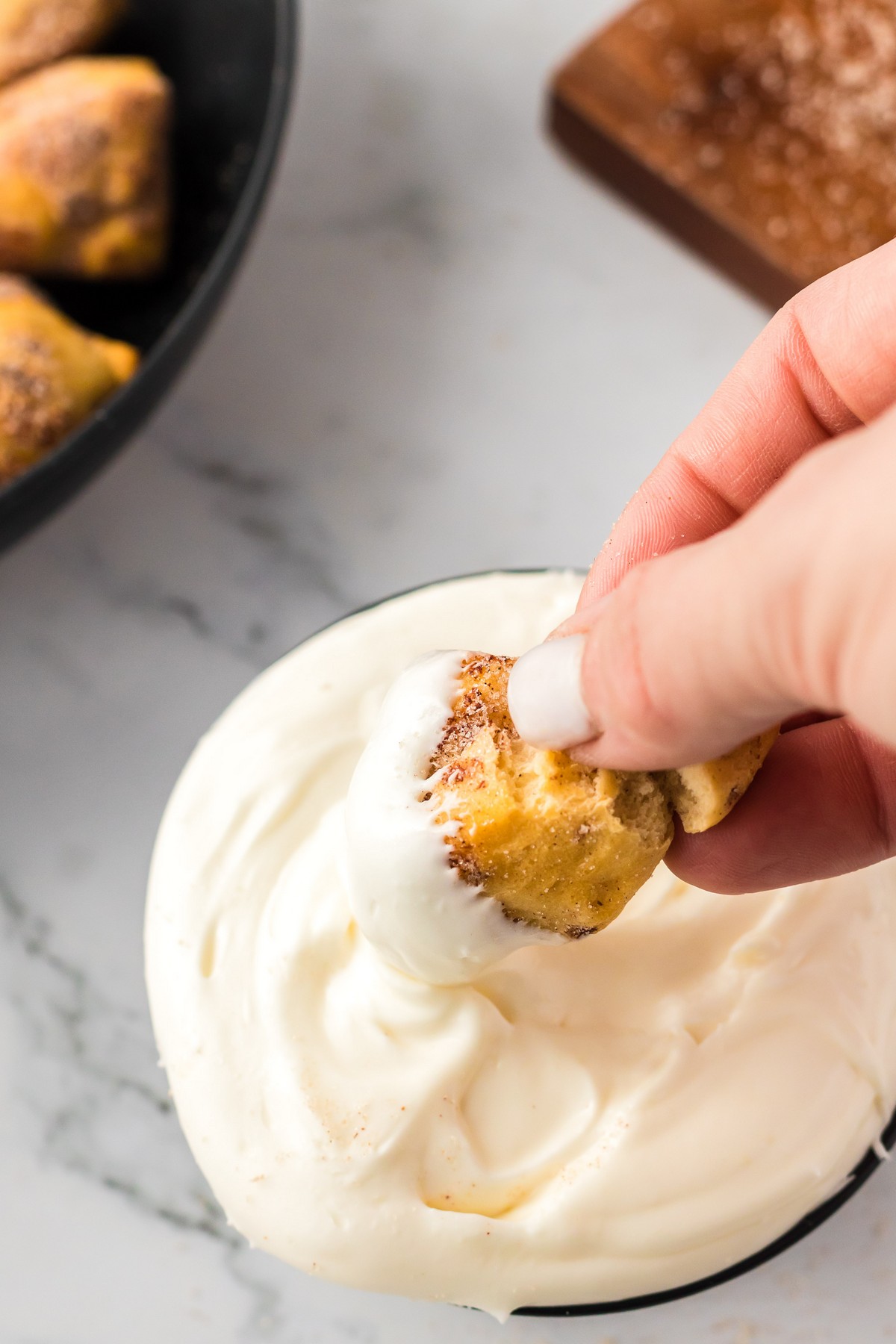 dipping cinnamon rolls into icing