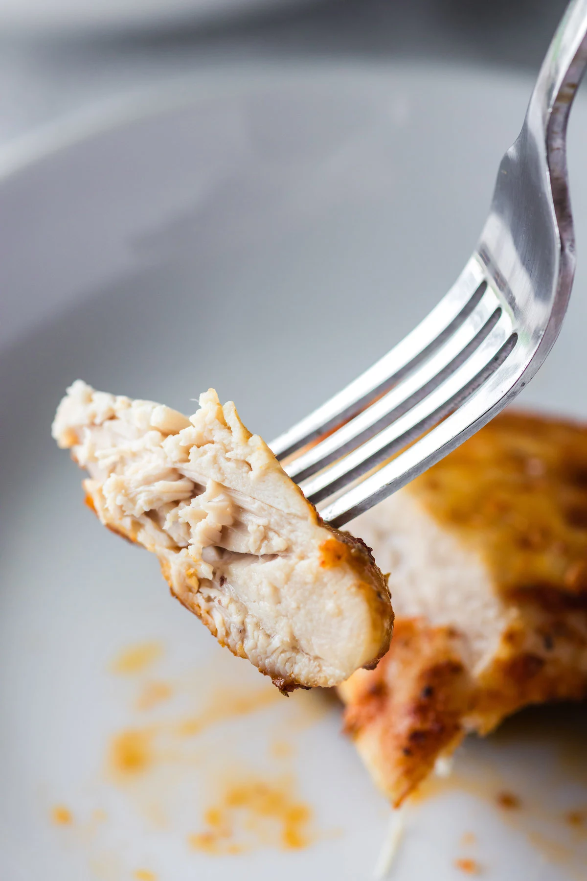 piece of chicken thigh on fork