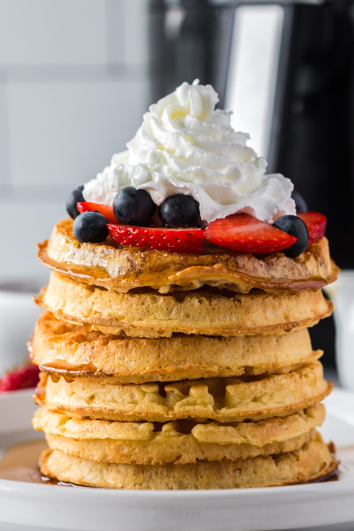 stack of waffles with berries and whipped cream