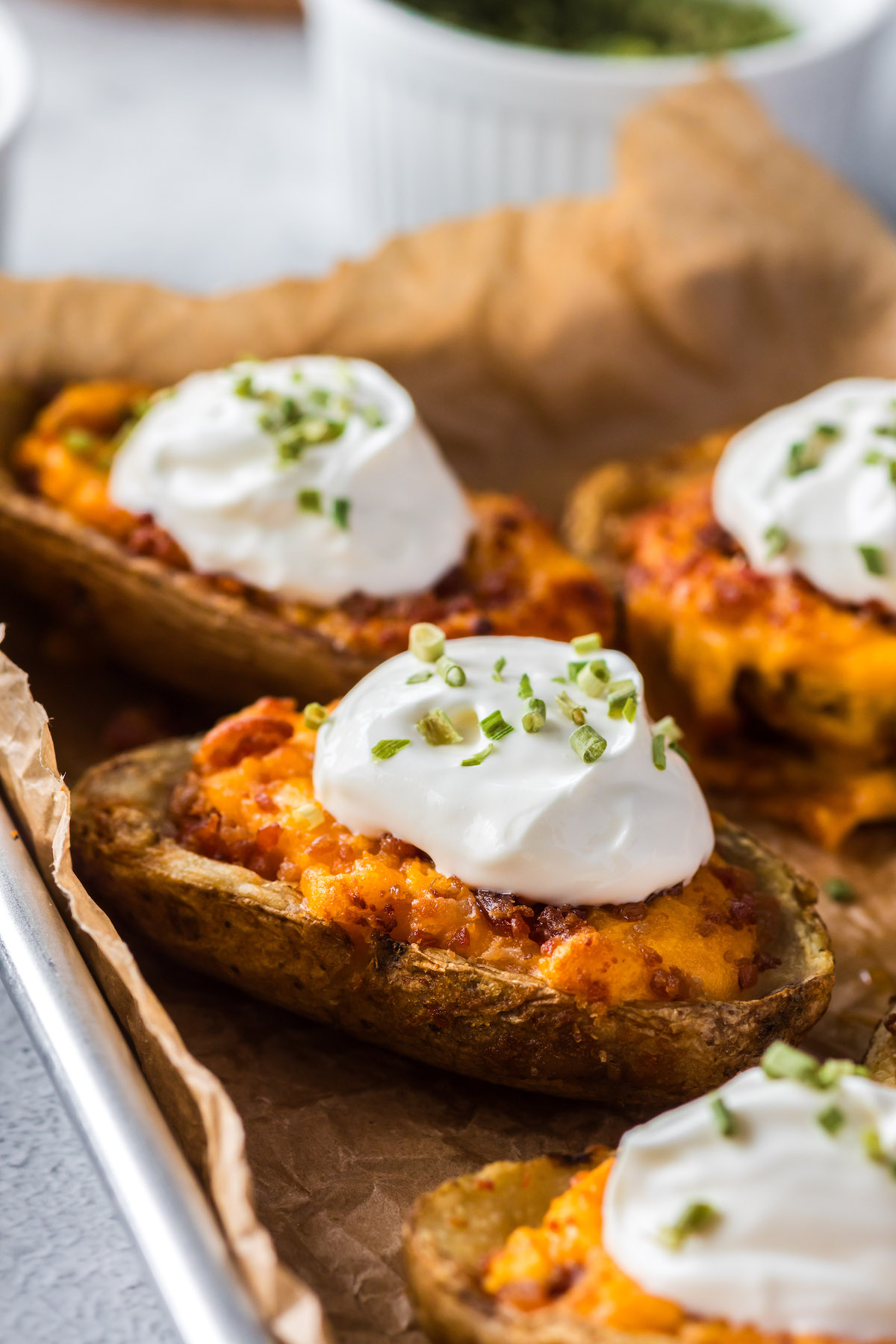 crispy air fryer potato skins with sour cream and green onion garnish