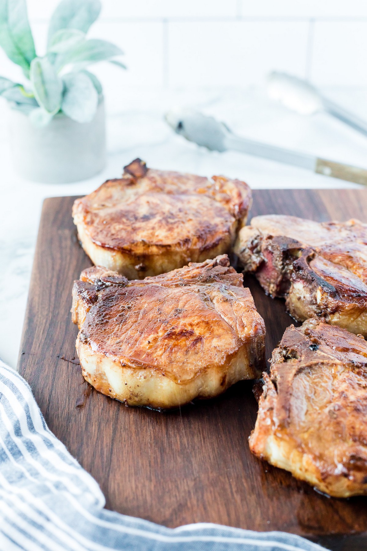 4 pork chops on cutting board resting