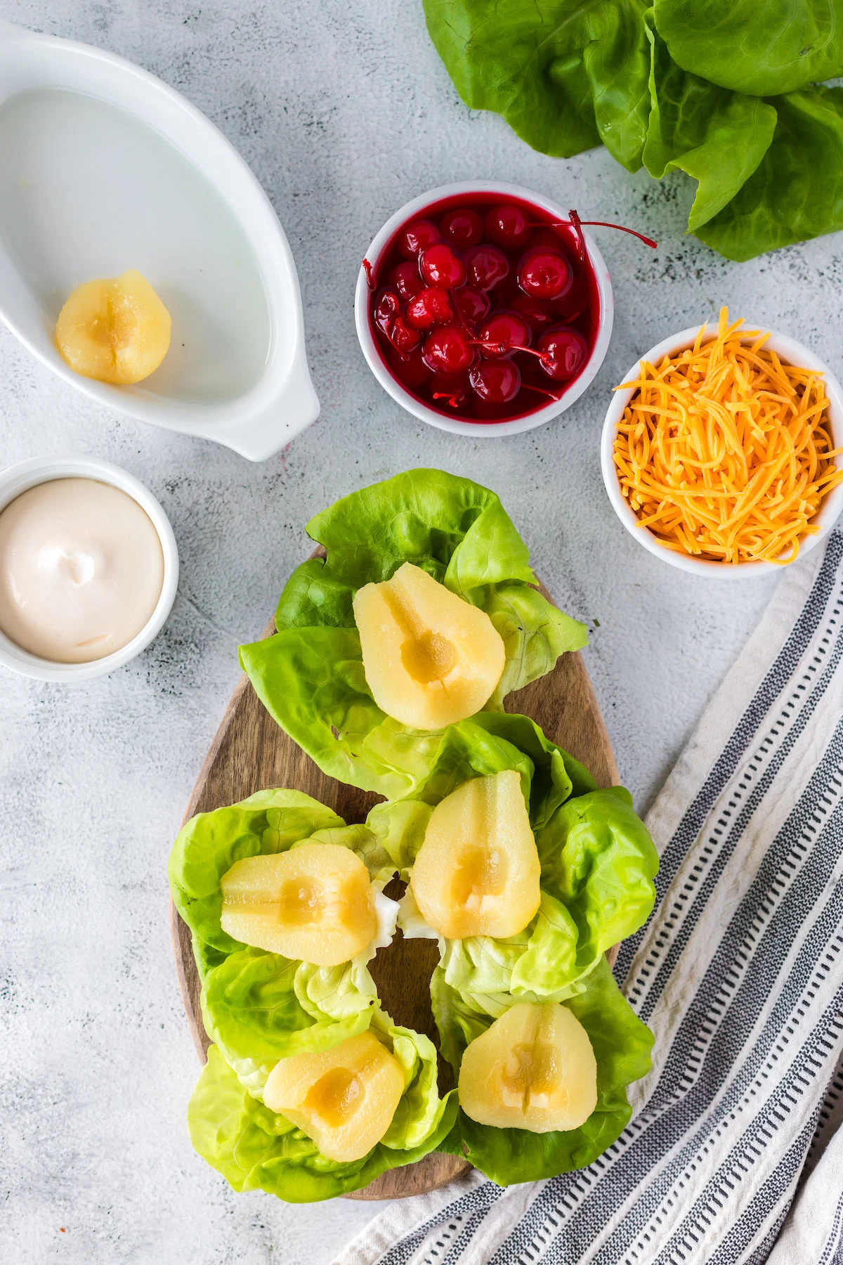 adding a pear half on each lettuce leaf