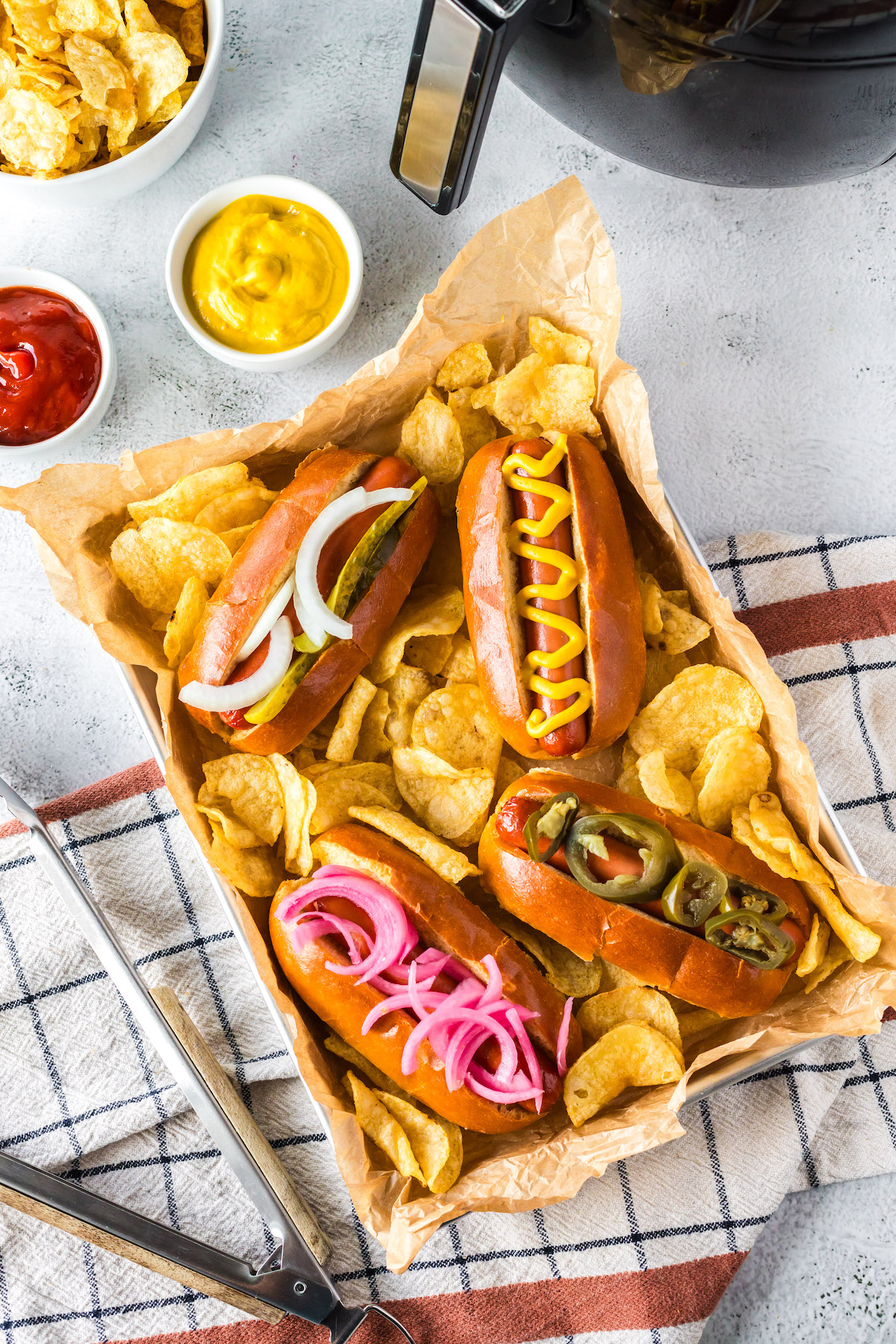 hot dogs served with chips and condiments
