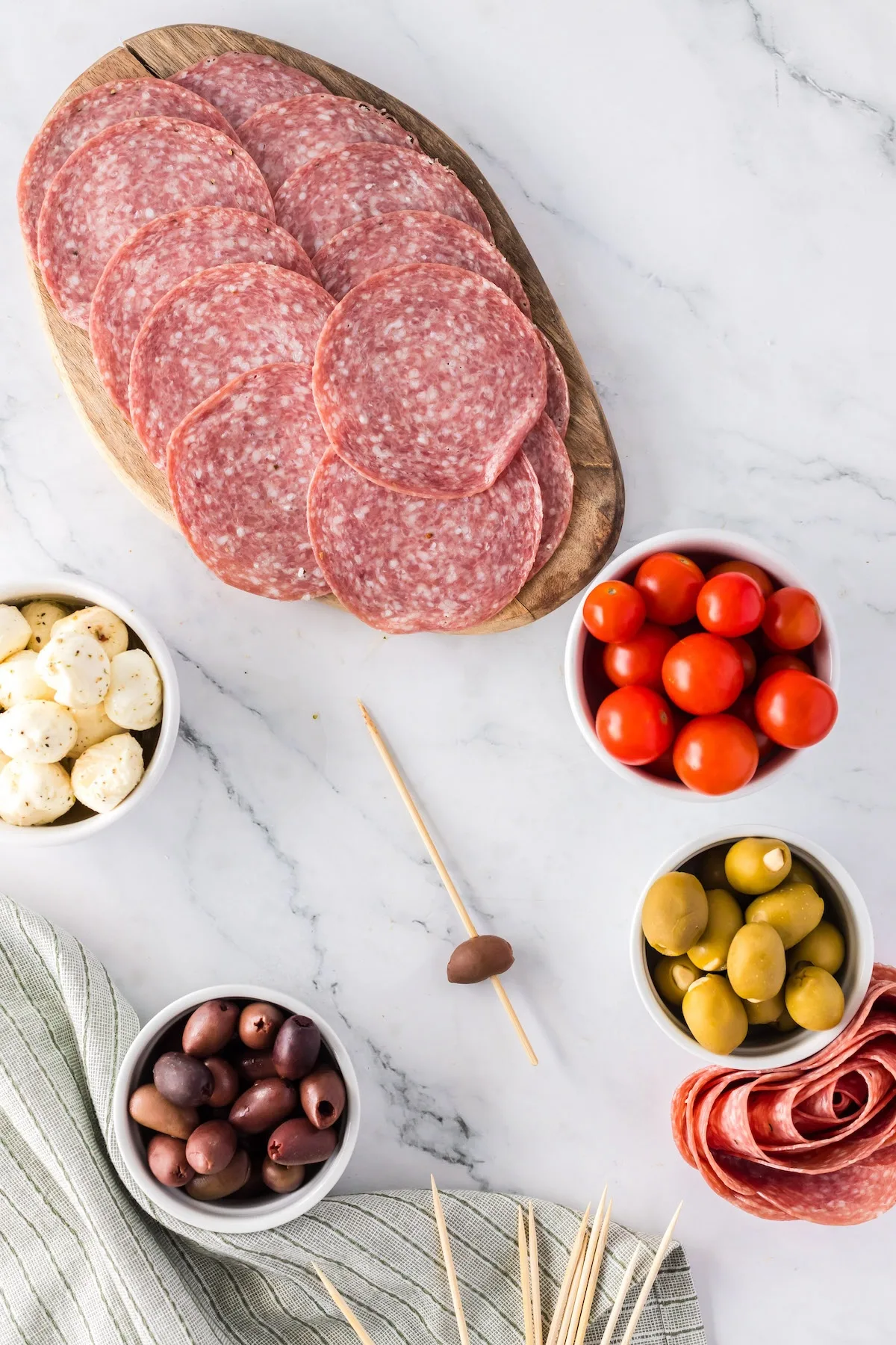 adding olive to charcuterie skewer