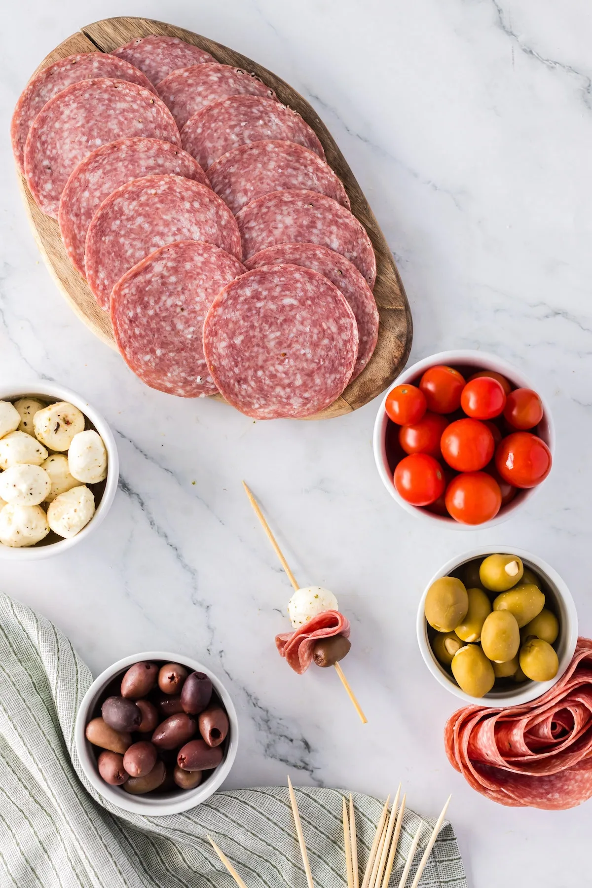 adding salami and mozzarella to to charcuterie skewer