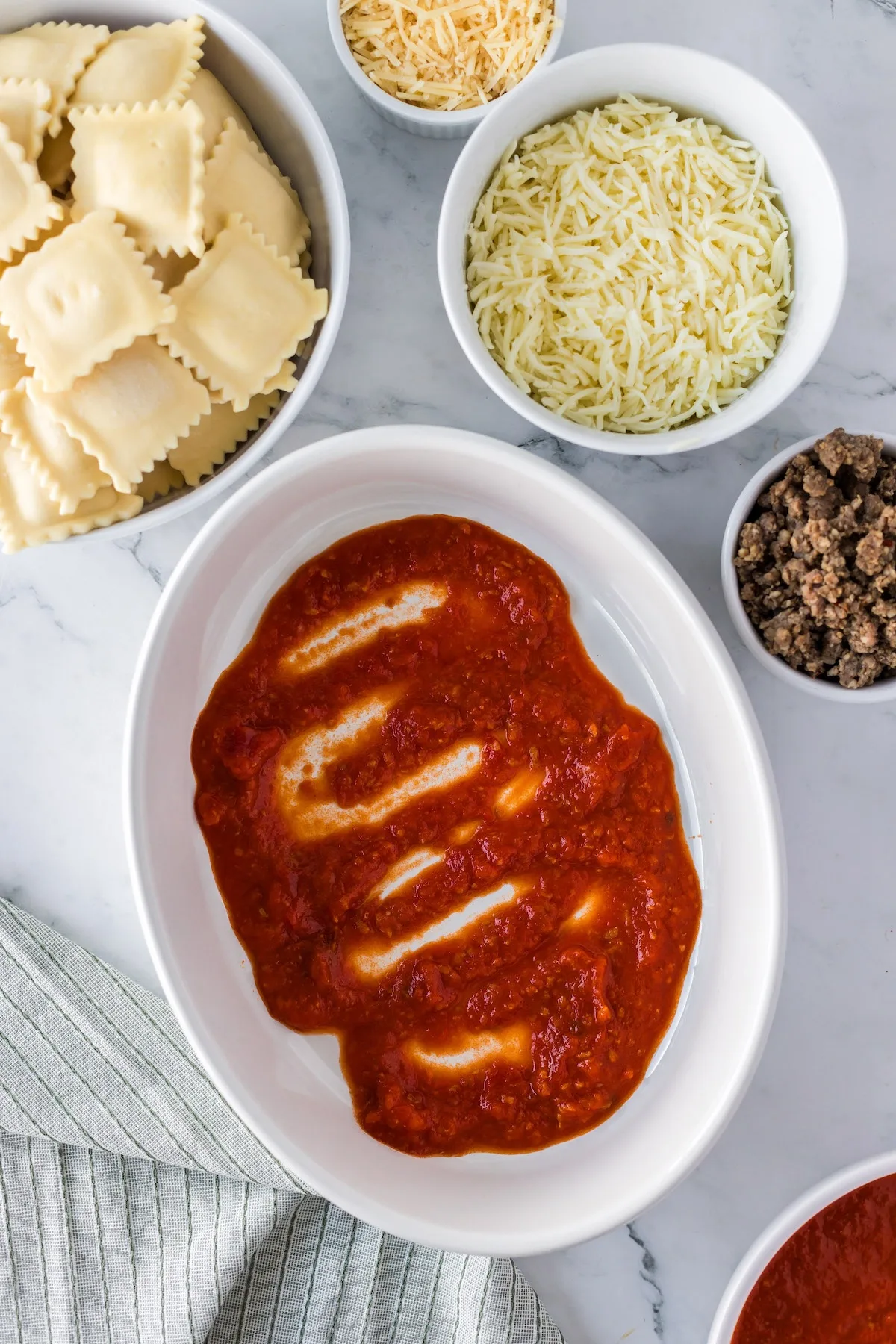 adding layer of marinara sauce to prevent pasta from sticking in bottom of casserole dish
