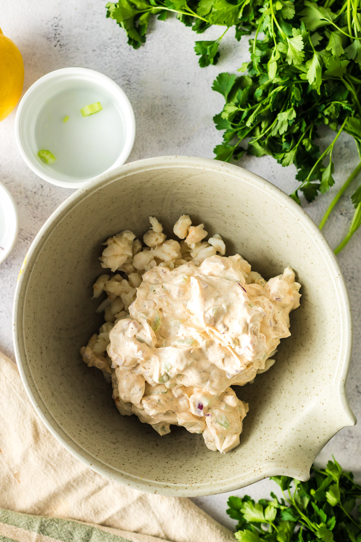 folding crab salad dressing into a bowl of lump crab meat