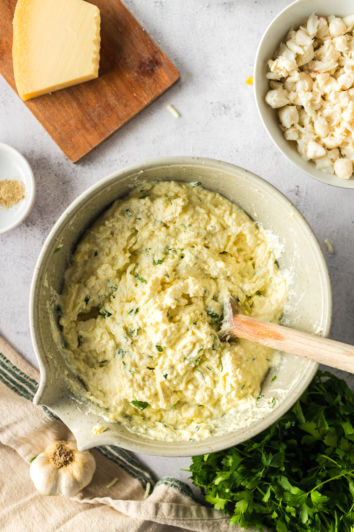 mixing together the cheese sauce for crab bake with mozzarella, ricotta, and egg