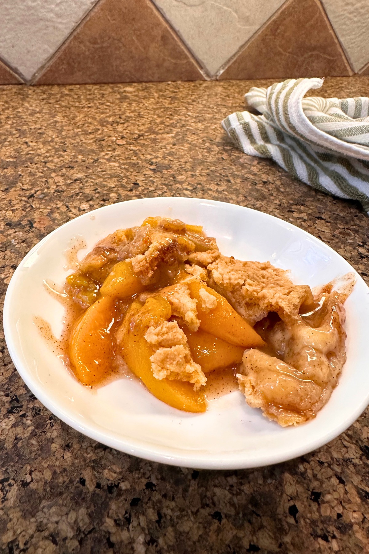 serving of peach cobbler on white plate