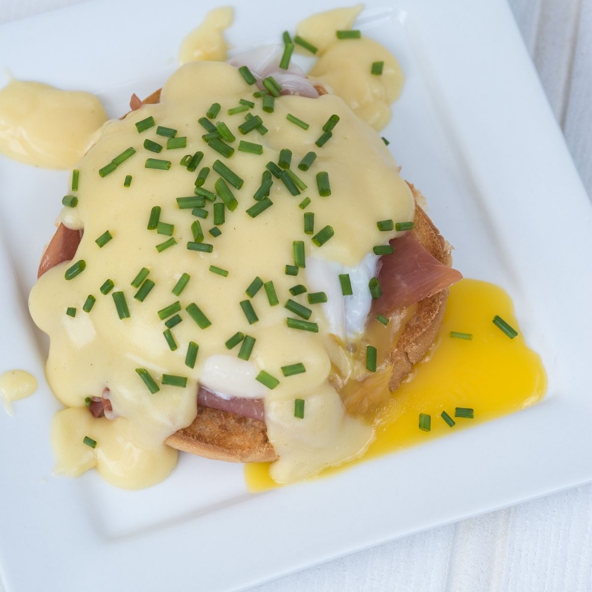 Hollandaise sauce over eggs benedict