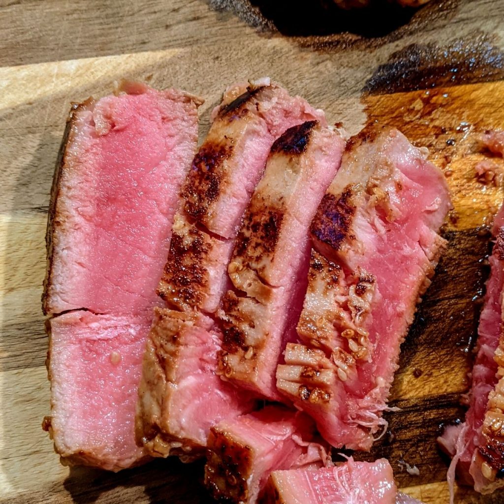 overhead image of seared and sliced ahi tuna on cutting board