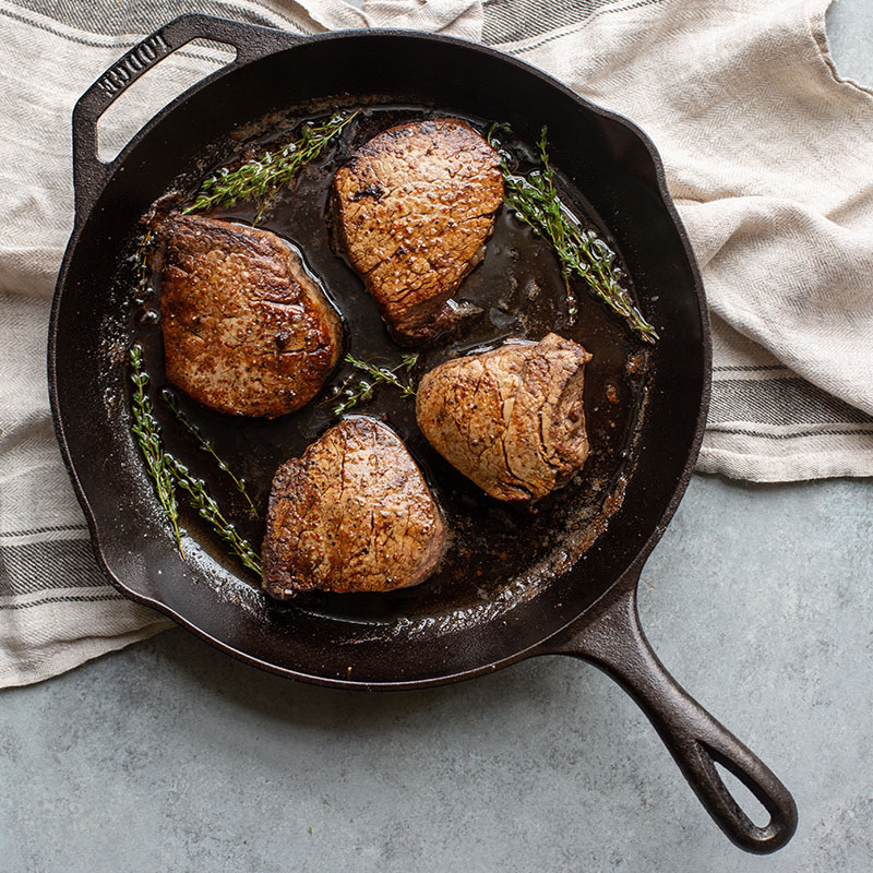 Cast iron pan with 4 steaks