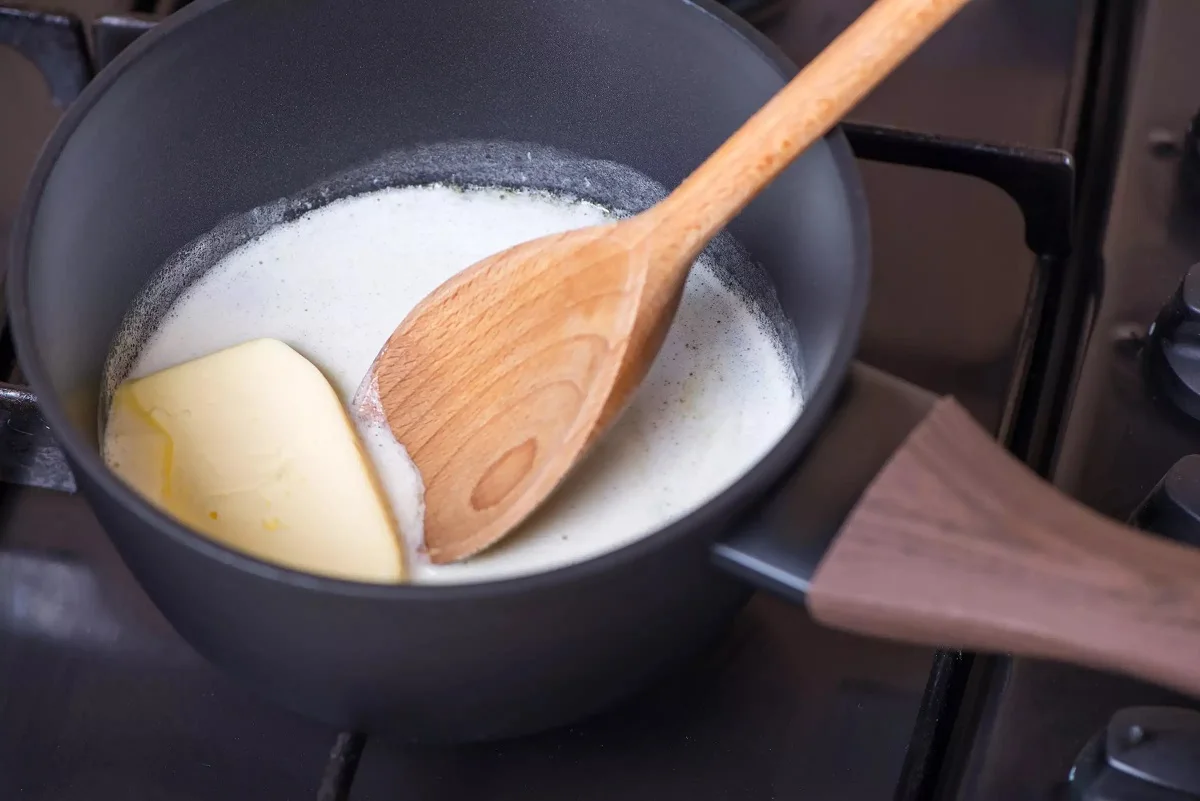 Melting butter into milk on stove