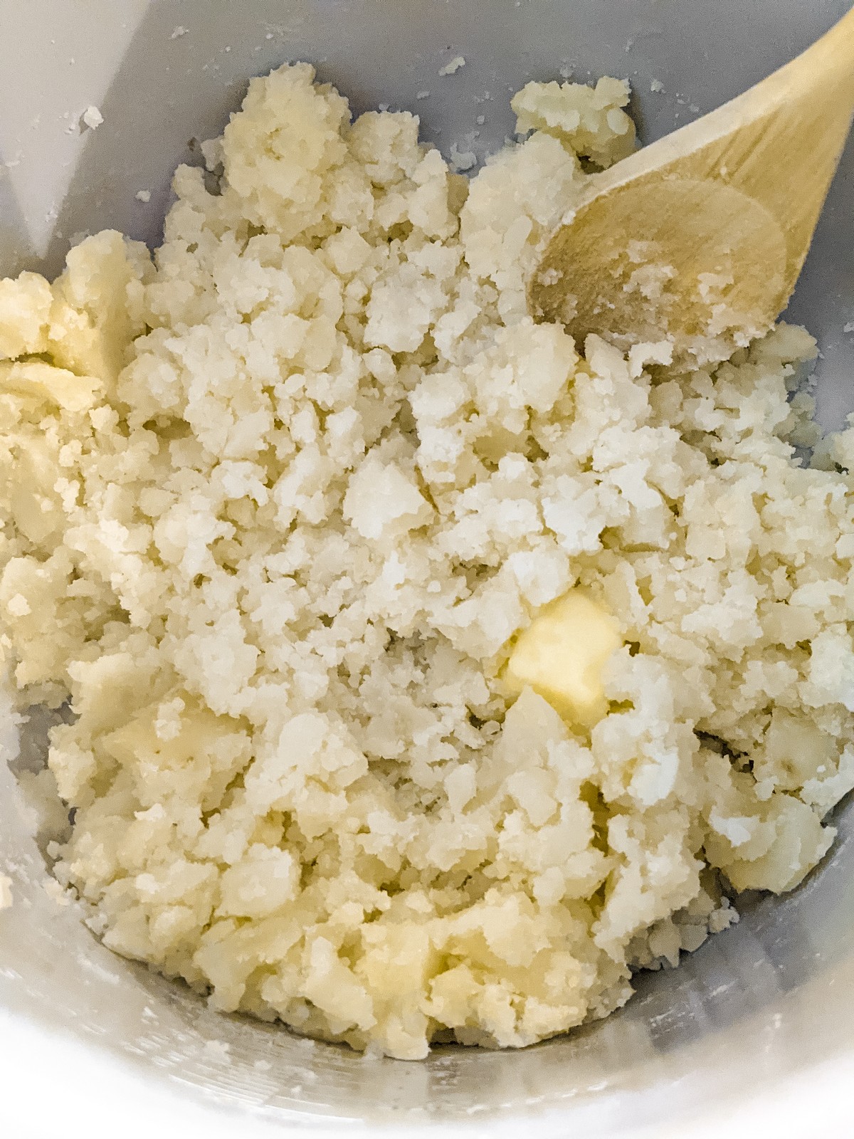 adding butter to mashed potatoes