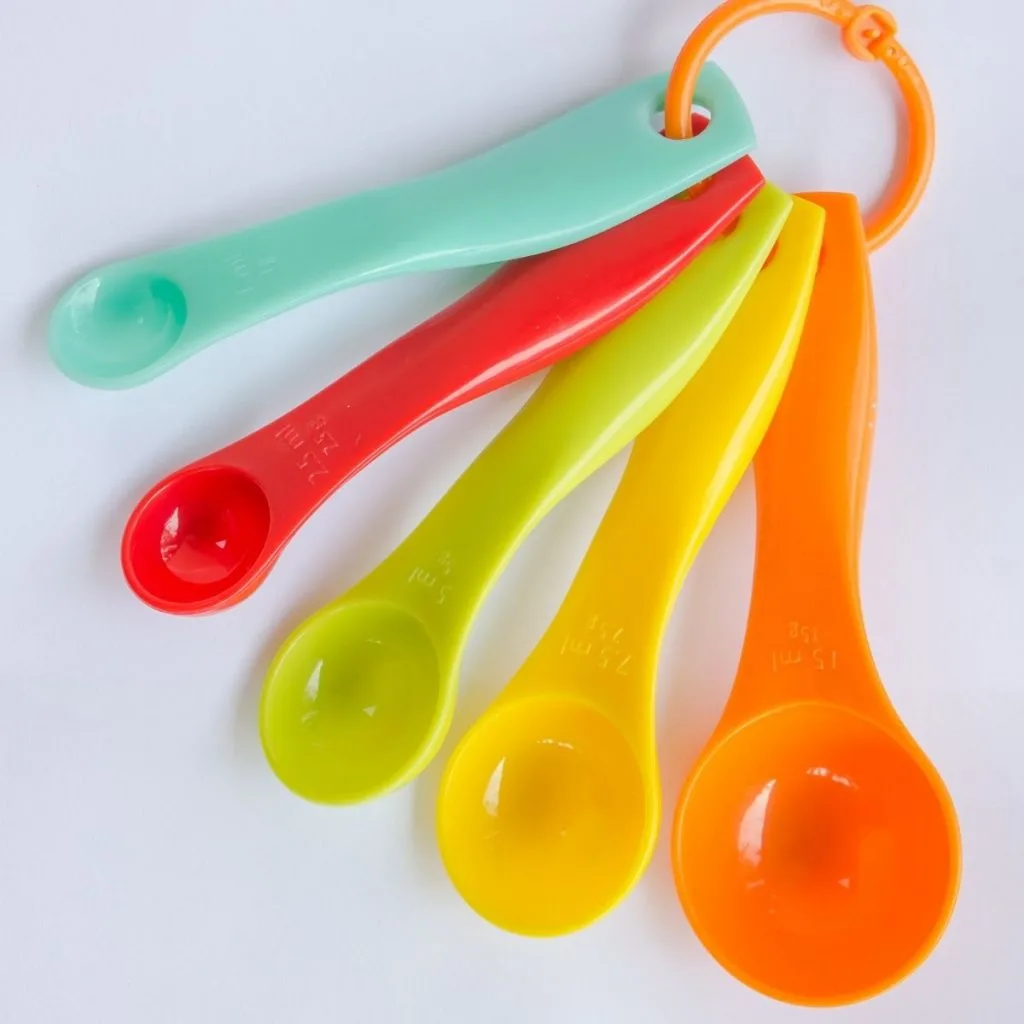 Colorful measuring spoons on white background