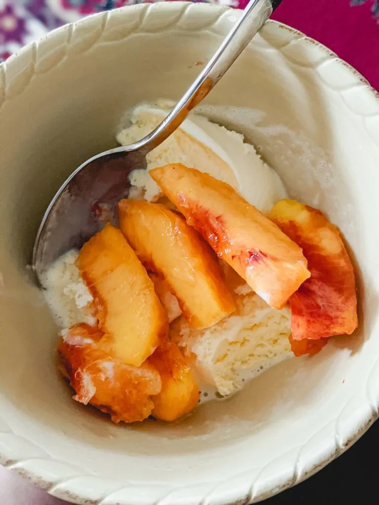 bowl of peaches over vanilla ice cream