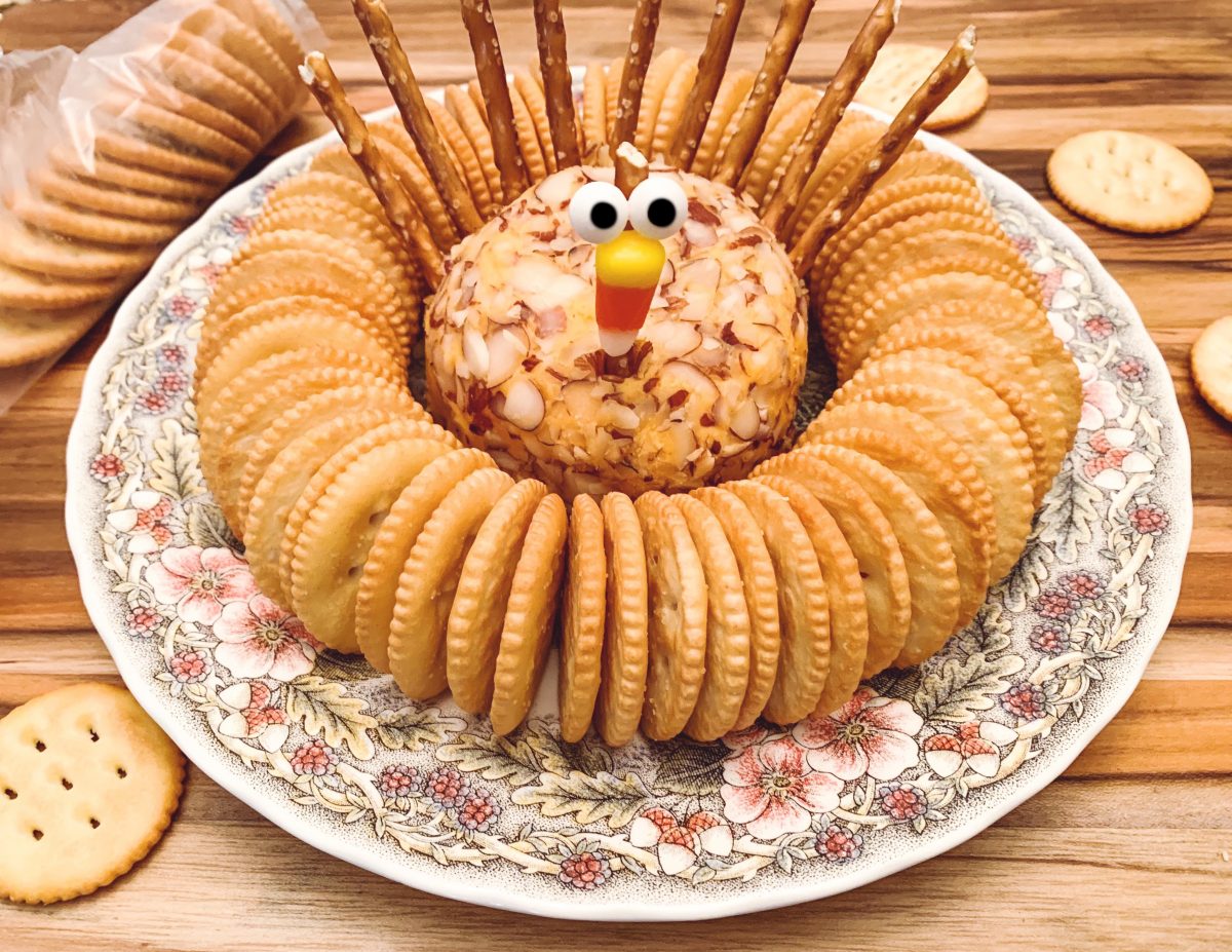 up close photo of turkey shaped cheeseball on plate surrounded by crackers